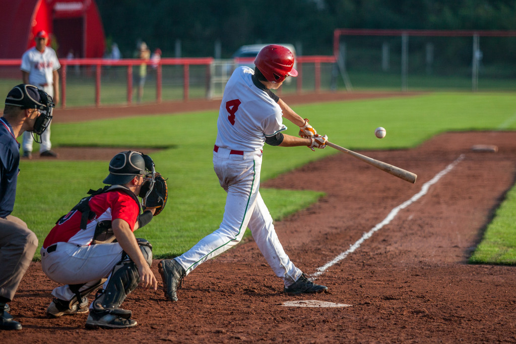 Baseball batter hitting a ball at a baseball game.