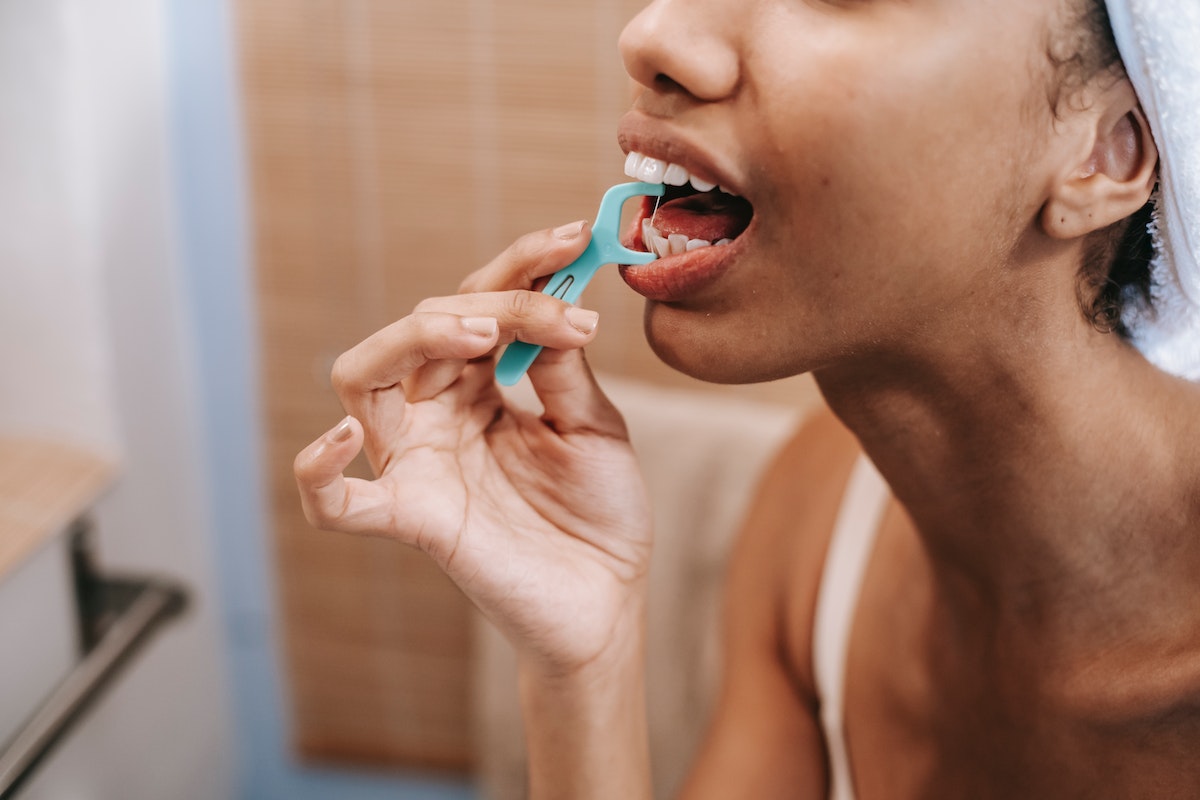 ethnic-woman-cleaning-teeth-with-dental-floss