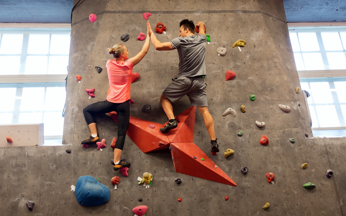 couple exercising through indoor rock climbing